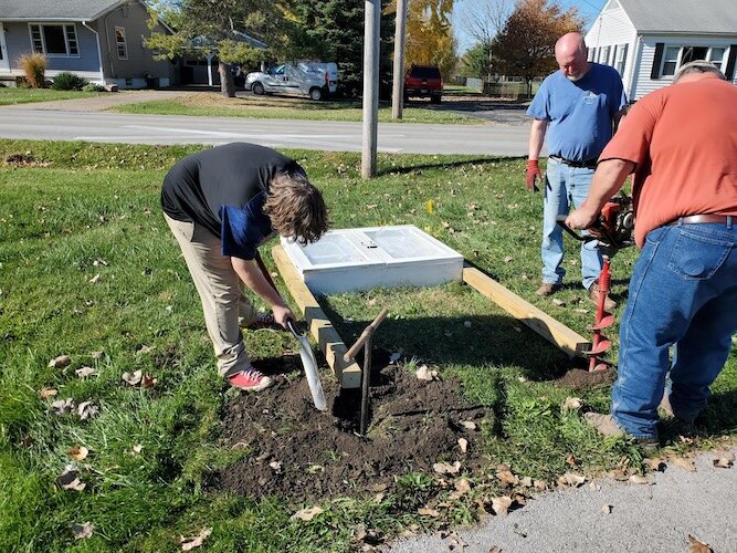 Kyle Werner, Dale Borzon, and Eric Wehner work on one of the Blessing Boxes.