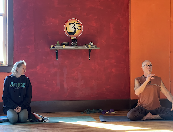 Brian Henderson talks with students in the Yoga Instructor Program class at Open Way Yoga in Huron in November.