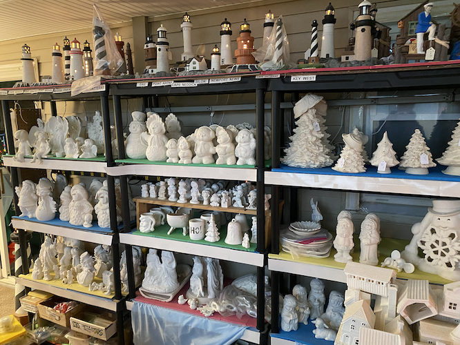 One wall of shelving contains Deal's unpainted pieces and lighthouses.