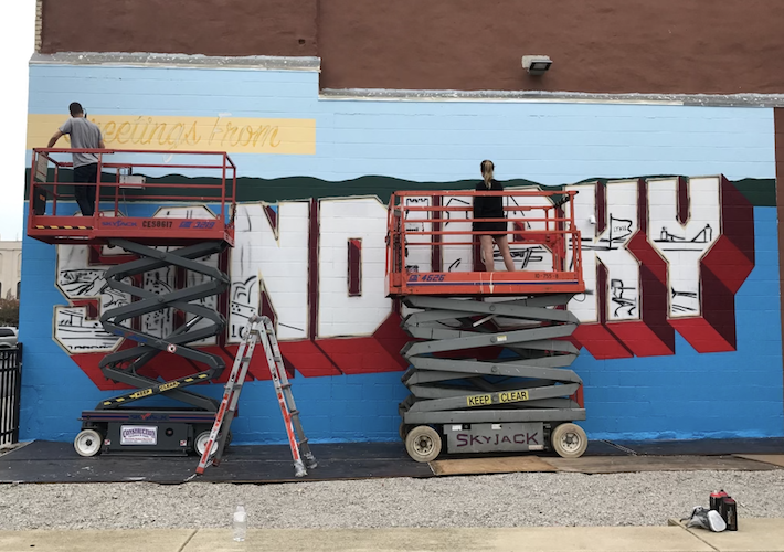 Ving and Beggs paint the first Greetings from Sandusky mural in 2018.