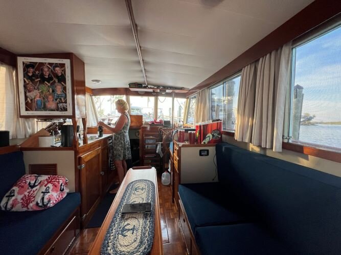 Tina Brown opens a bottle of wine in the cabin of the Tina B.