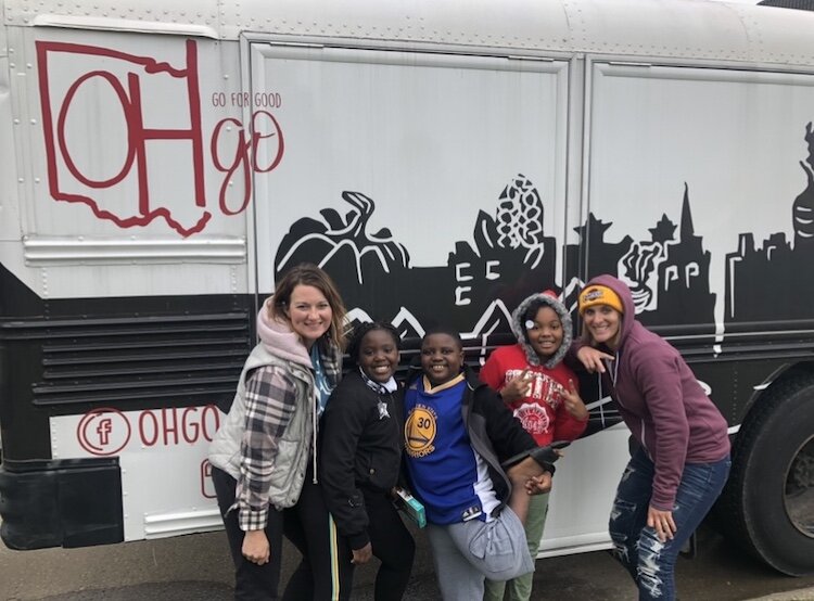 Boesch and Faulkner pose with kids at a mobile pantry event.