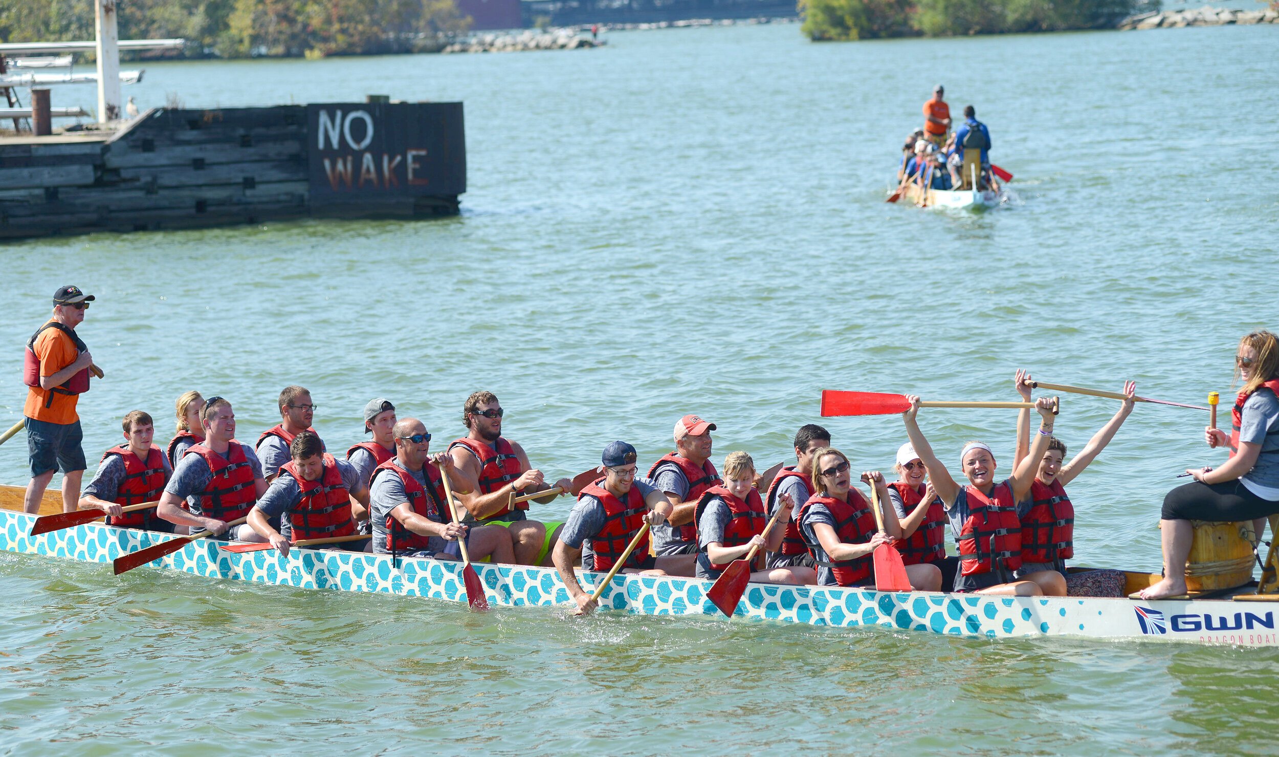 Teams of 20 paddle in dragon boats in Sandusky Bay during the 2019 Dragons & Bacon Fest.